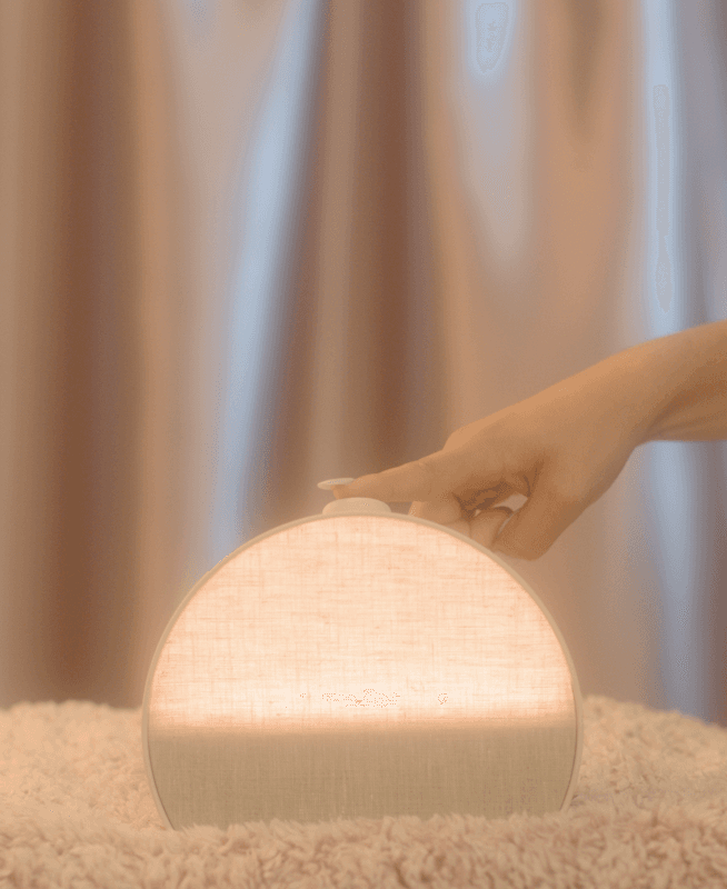 Hand tapping the top button on a Hatch Restore 3