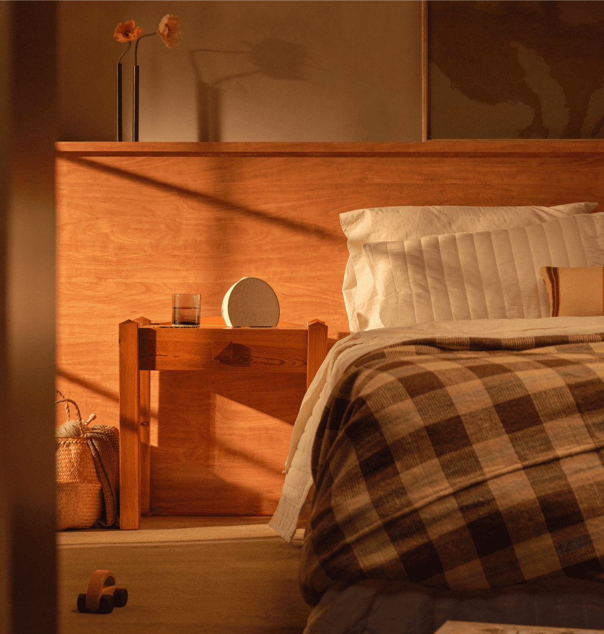 Wide shot of a Hatch sleep clock next to a made bed