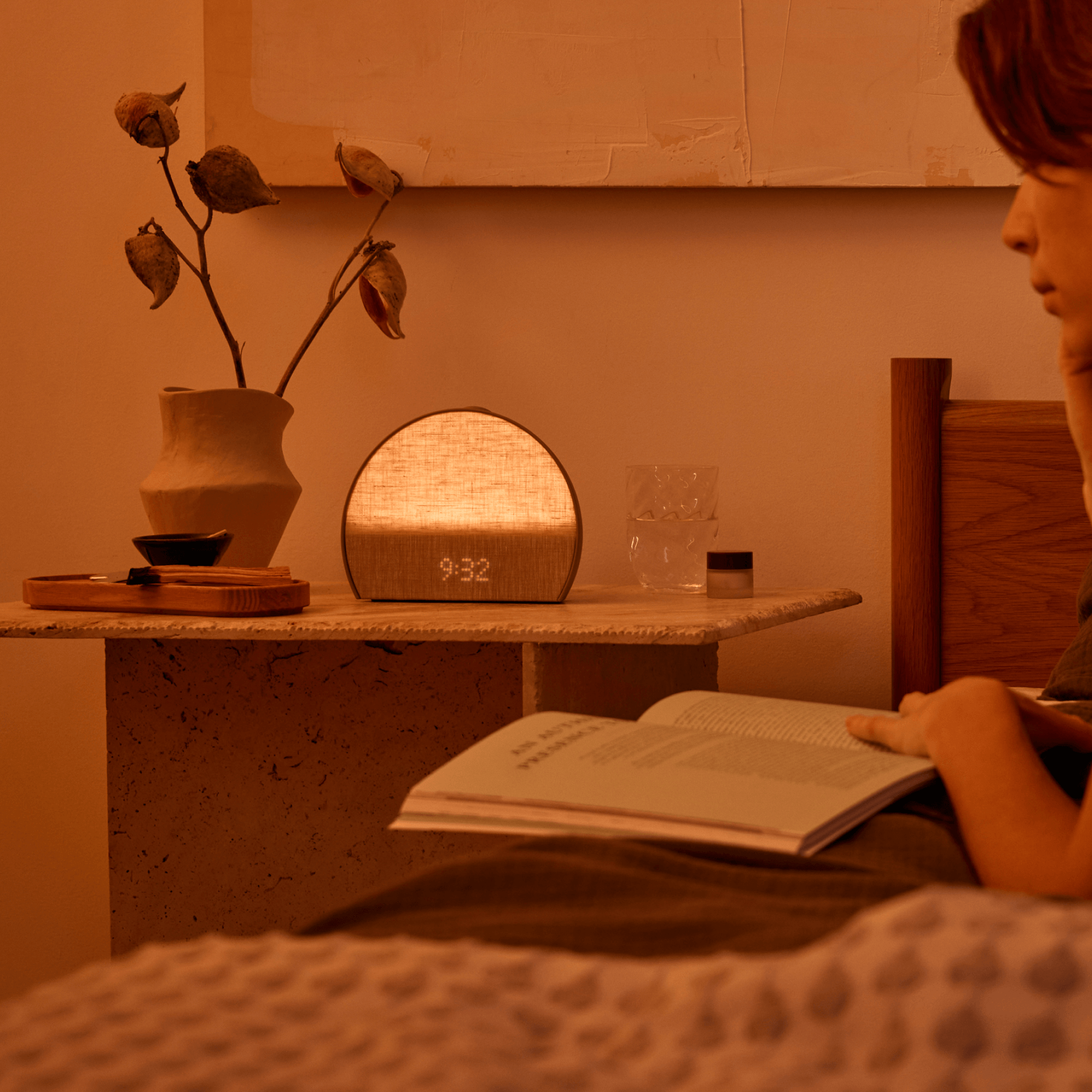 Restore 3 on a bedside table next to a woman reading